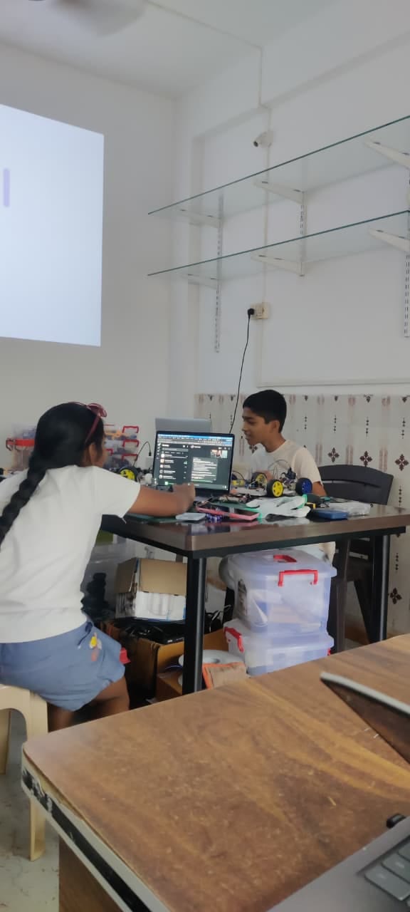 Two students building a robot car together in the lab